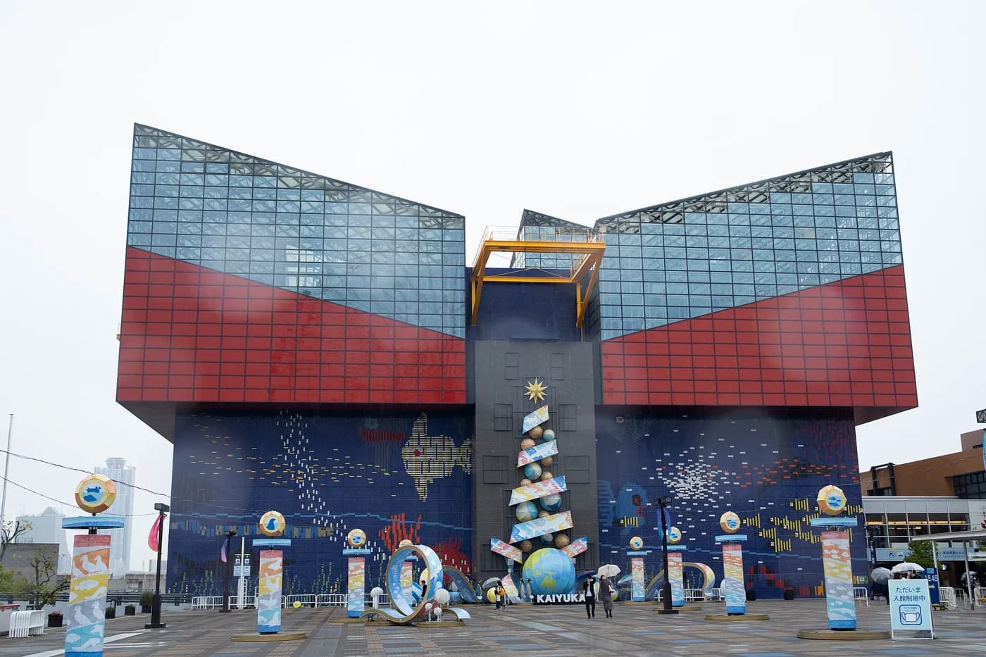 海遊館の入口側の外観。赤と青の壁に魚の絵が描かれた建物