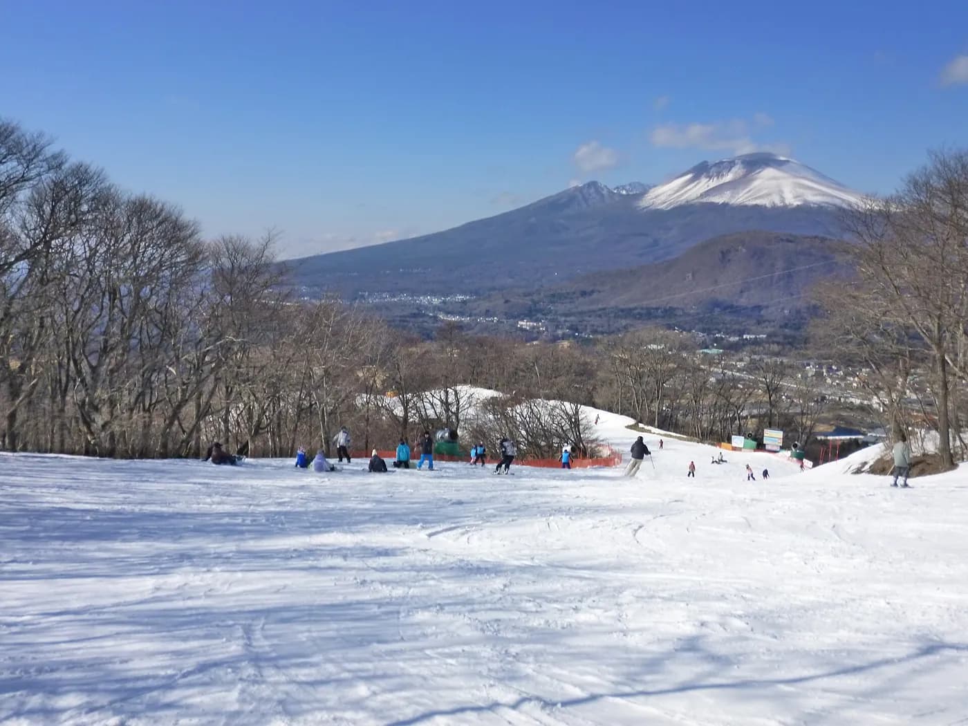 雪の積もった軽井沢プリンスホテルスキー場のゲレンデと、奥の浅間山