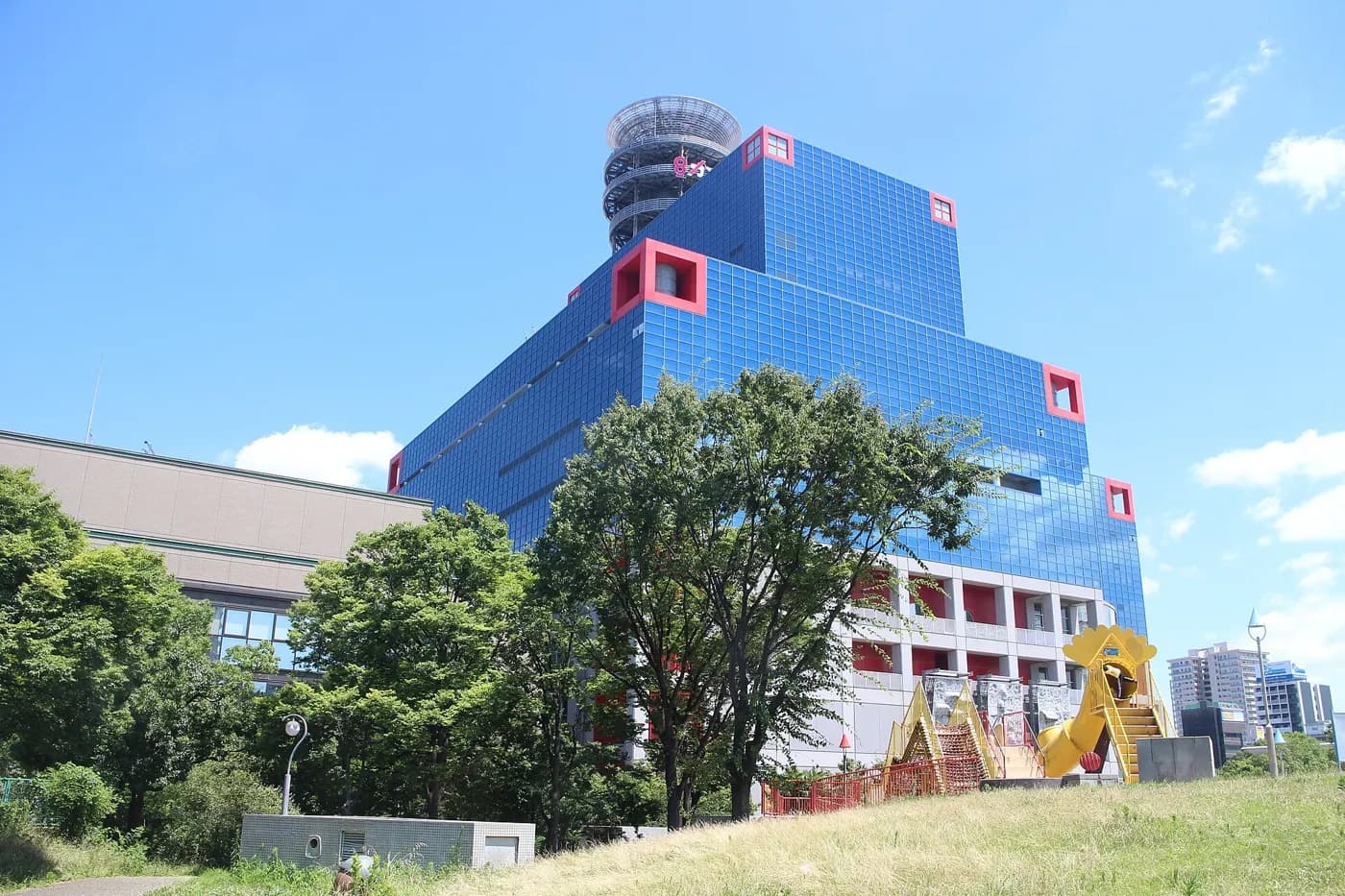 キッズプラザ大阪が入る扇町の建物。青い壁に赤い窓枠の外観